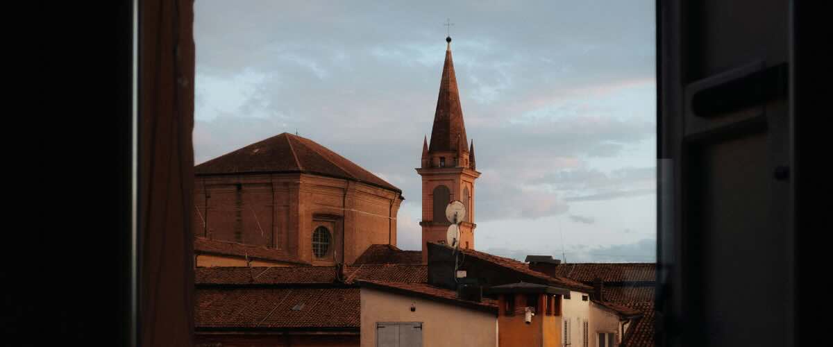 Historic Modena rooftops during summer, the Italian city where Schedoni leather craftsmanship began