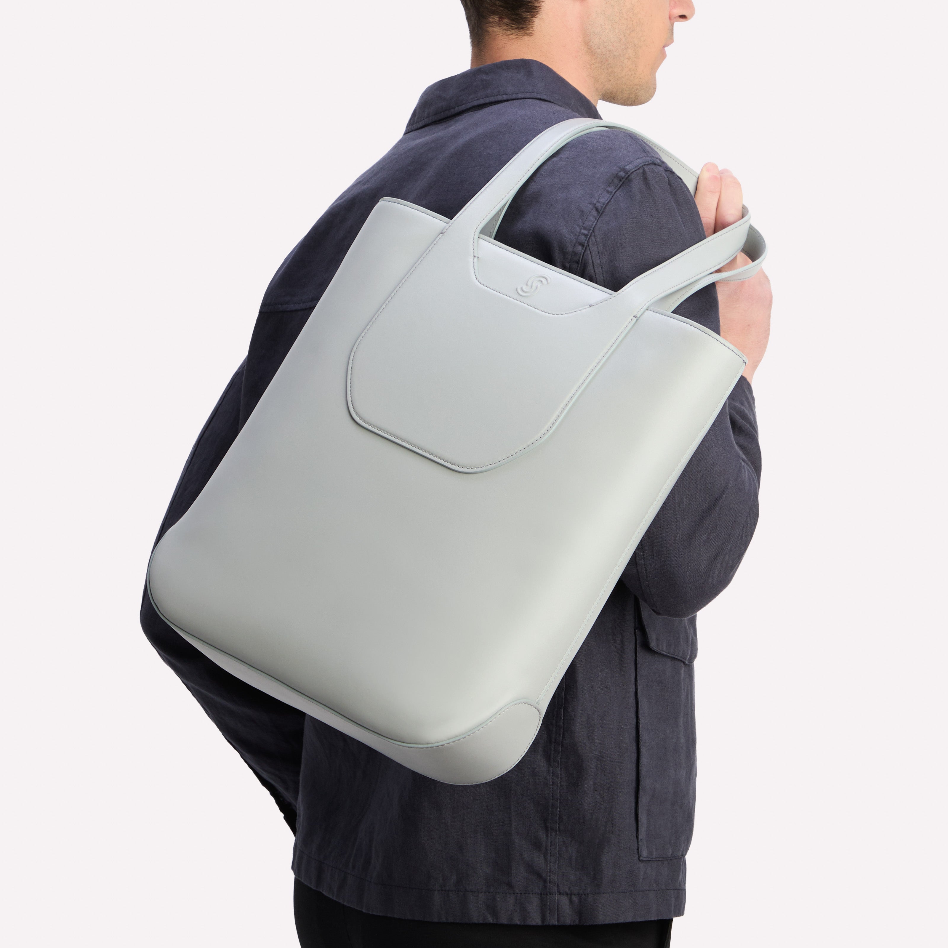 Model holding a Cezanne & Lavanda Tote gray over shoulder on a white background